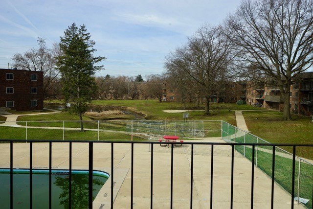 A pool and a red object in the middle of a grassy area.
